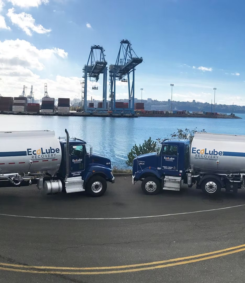 Two EcoLube Recovery tanker trucks parked at a port terminal